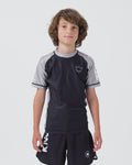 Kingz Ranked Youth S/S Rashguard Grey - Full Body Front View Youth Athlete Black Body Grey Sleeves Crown Logo Chest Bold KINGZ Text Sleeve Athletic Fit No-Gi BJJ Training [color:Grey]