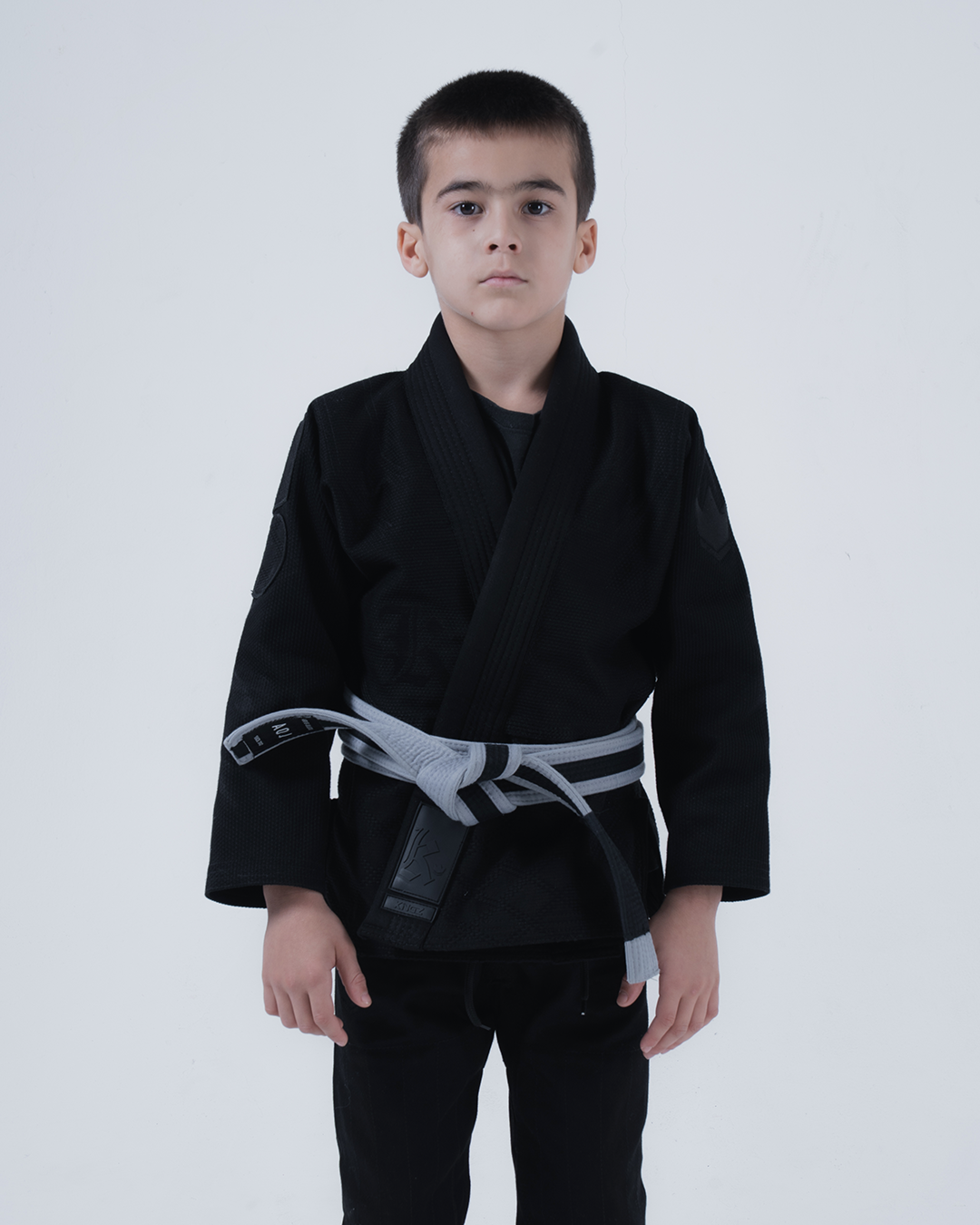 Kingz Born to Rule Youth Jiu Jitsu Gi - Black - Full Body Front View Young Athlete Black Gi Gray Belt Kingz Logo Patch Left Arm Durable Stitching Youth BJJ Gi Training [color:Black]
