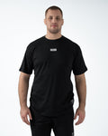 Kingz Slant Bar Tee Black - Front View Male Athlete KINGZ Logo Center Chest Solid Black Short Sleeve Casual Fit BJJ Training T-Shirt [color:Black]