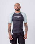 Kingz Breeze Rashguard Black - Full Body Front View Male Athlete Light Blue Patterned Sleeves KINGZ KIMONOS Text Chest Athletic Fit BJJ No-Gi Training Rash Guard [color:Black]