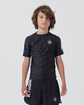 Kingz Kore V2 Youth S/S Rashguard Navy Black - Full Body Front View Teen Boy Athlete Short Sleeve Navy Blue Minimal Design White Crown Logo Circle Chest KINGZ White Sleeve Text Matching Navy Shorts Crown Logo Hem Kids BJJ Training [color:Black]