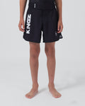Kingz Kore V2 Youth Shorts Black - Full Body Front View Teen Boy Athlete Solid Black Bold Vertical KINGZ White Text Left Leg Circular Crown Badge Right Competition Cut Kids Grappling Shorts No-Gi BJJ Kore Collection [color:Black]