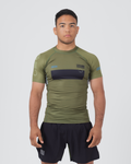 Kingz Trooper Rashguard Military Green - Full Body Front View Male Athlete Short Sleeve Olive Green Black Chest Band KINGZ Text Flag Patch Blue Dot Pattern Sleeves Gray Side Panels Shorts [color:Black/Green]