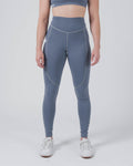 Kingz Kore Women's Grappling Spats Smoke Blue - Full Body Front View Female Athlete Slate Smoke Blue Color High-Waist V-Seam Detail Side Pocket Right Thigh Matching Sports Bra Full-Length Compression Fit Women's No-Gi BJJ Spats Kore Collection [color:Steel Blue]