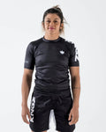 Kingz Ranked Performance S/S Rashguard V1 Black - Full Body Front View Female Athlete Black Rashguard White KINGZ Text Sleeve Crown Logo Chest BJJ No-Gi Grappling Rash Guard [color:Black]