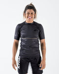Kingz Relentless S/S Rashguard Black - Front View Female Athlete Short Sleeve Black Textured Pattern Subtle Logo Left Chest Small White Text Right Sleeve BJJ No-Gi Rash Guard