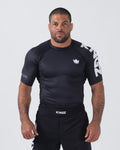 Kingz Ranked Performance S/S Rashguard Black - Full Body Front View Male Athlete White KINGZ Text Sleeve Crown Logo Chest Form-Fitting Design BJJ No-Gi Grappling Rash Guard [color:Black]